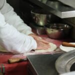 Pizzaiolo wyrabia ciasto na pizzę