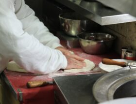 Pizzaiolo wyrabia ciasto na pizzę