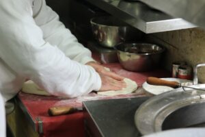 Pizzaiolo wyrabia ciasto na pizzę