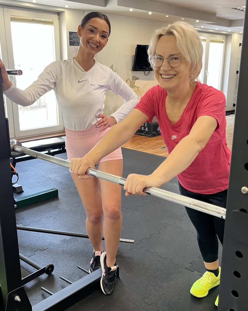 Trenerka personalna Body Movement Mokotów kontroluje technikę podopiecznej podczas treningu indywidualnego.